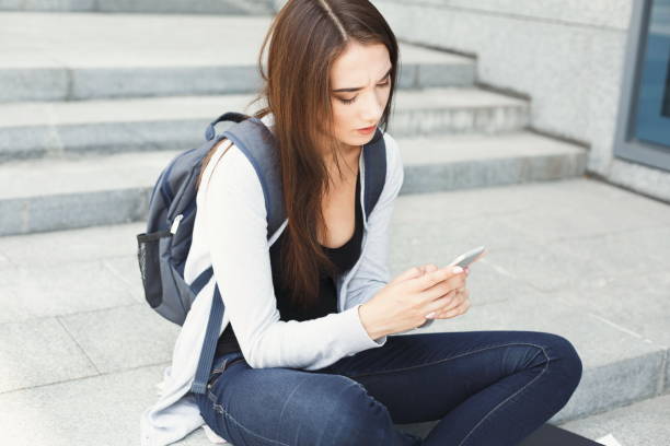 istock Young woman using smartphone outdoors 932302028