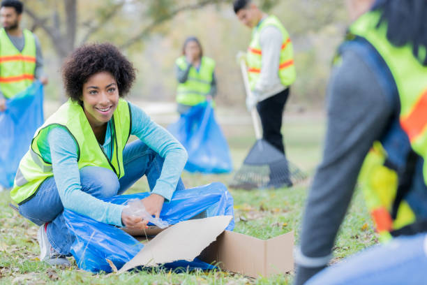 istock Cheerful young woman during community cleanup day 932303996