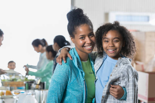 istock Happy mom and daughter in local soup kitchen 932306400