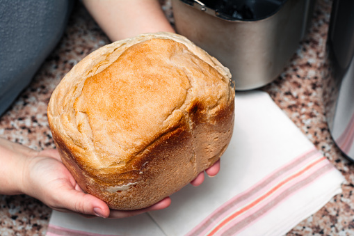 Homemade bread in hands,  baked in a bread maker