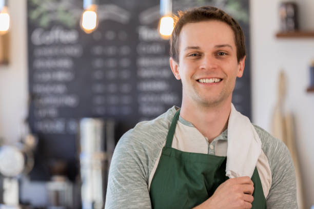 młody mężczyzna właściciel kawiarni pozuje do kamery - caffeine caucasian satisfaction small business zdjęcia i obrazy z banku zdjęć
