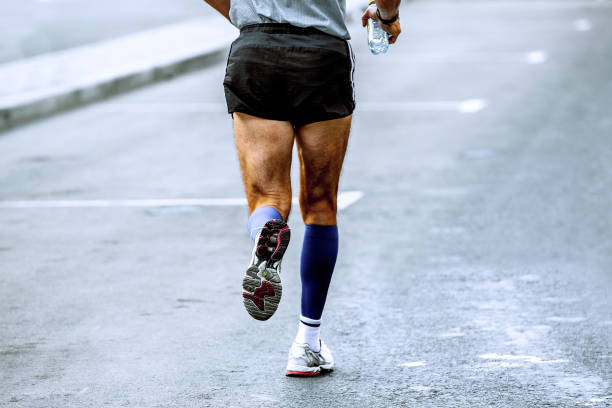 istock back athlete runner in hand water bottle run in street 932318936