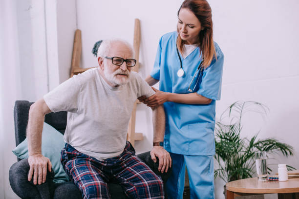 istock Nurse helping old man to stand up from chair 932319474