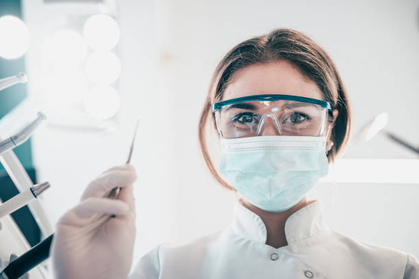 istock Skillful Young Female Dentist is Treating Patient Teeth 932321692