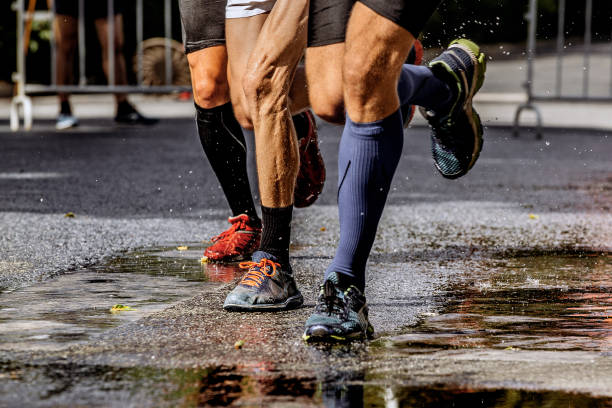 istock group runner men running wet street in water spray 932334270