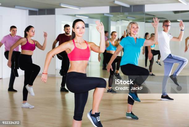 Vigorous Men And Ladies Dancing Aerobics At Lesson Stock Photo - Download Image Now - Aerobics, Learning, 50-59 Years