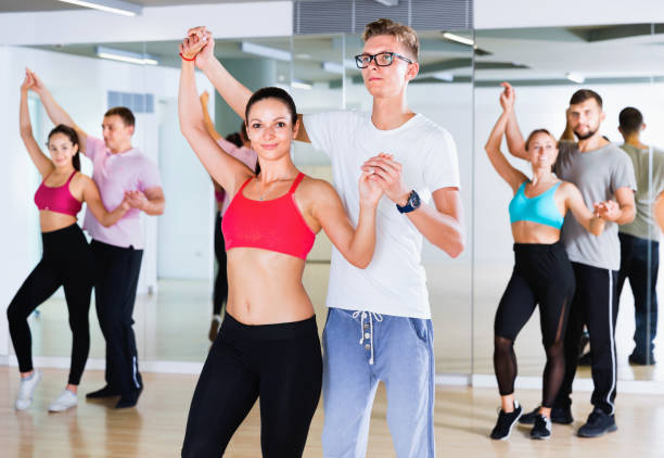 istock Group of  young adults dancing salsa in club 932334356