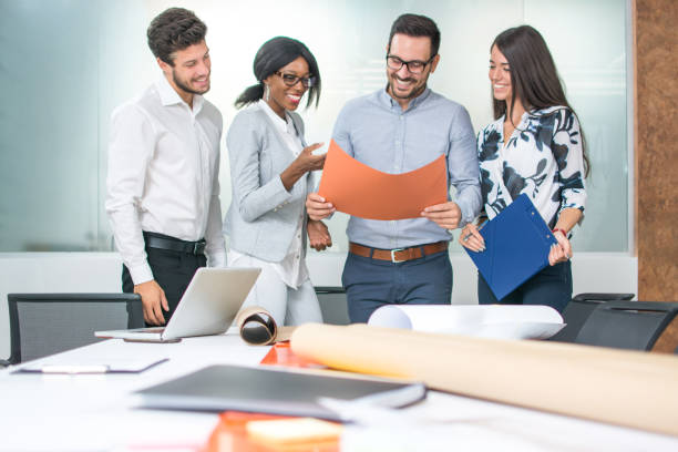 istock Group of architects working on plans near business boardroom table. 932335226
