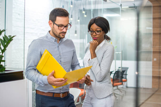 istock Beautiful business woman and man analyzing contract in office. 932339880
