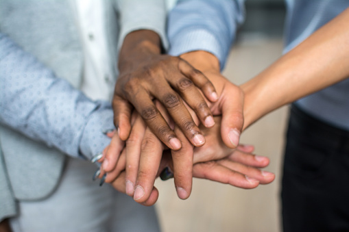 Multiracial business people stacking hands over each other