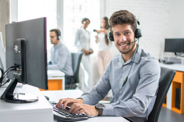 souriant homme client support opérateur de téléphonie avec casque travaillant dans le centre d’appels. - receptionist customer service customer service representative photos et images de collection