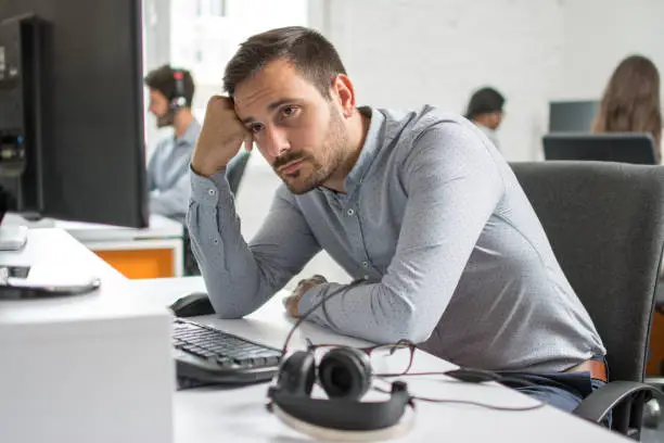 Photo of Worried beard man looking at computer screen in office