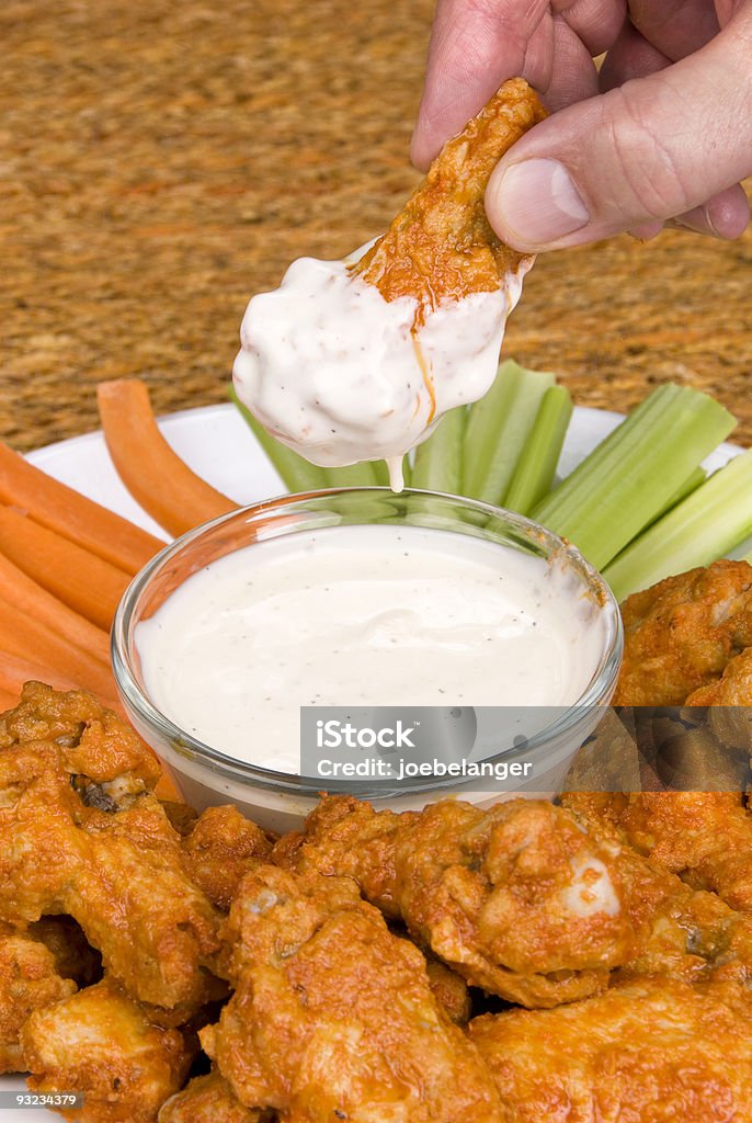 Alitas de pollo con salsa caliente y aderezos - Foto de stock de Ala de pollo libre de derechos