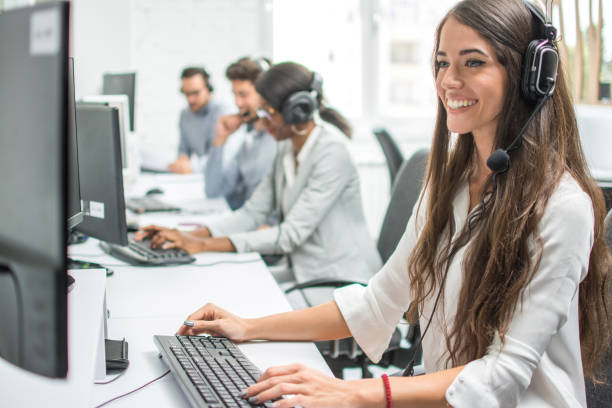 jeune souriant opérateur femme agent avec les casques travaillant dans un centre d’appels. - receptionist customer service customer service representative photos et images de collection