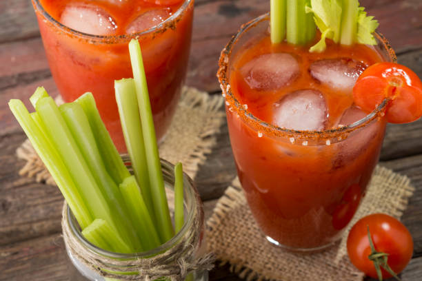 Cold Bloody Mary Cocktail High angle view of a Bloody Mary cocktail with vodka, lemon and tomato juice, tabasco sauce and ice cubes decorated with celery leaves bloody mary stock pictures, royalty-free photos & images