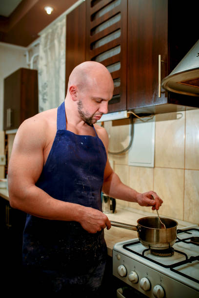 istock A young man chef stands behind a stove 932357074