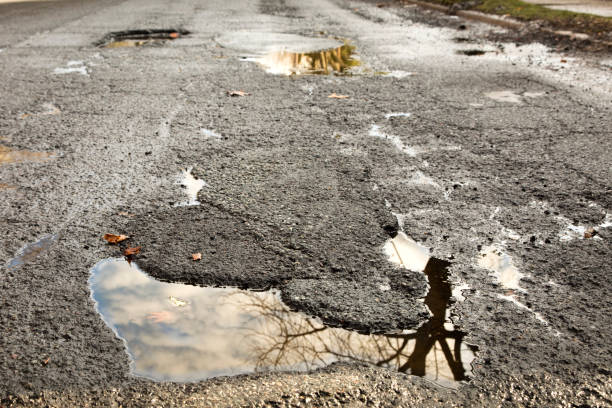 istock Large dangerous pothole in middle of the road 932357984