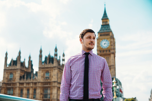 Young businessman in smart casual clothing in London, during rush hour on the streets of Central London. Successful business person doing business in London