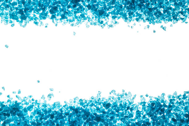 istock Crystals of blue sea salt. Border on white background 932361954