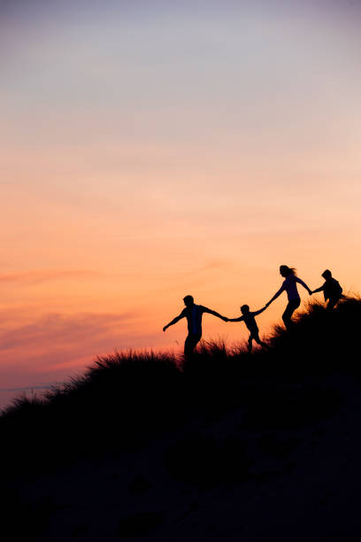 silueta de familia corriendo por las dunas de arena - holding hands child silhouette family fotografías e imágenes de stock