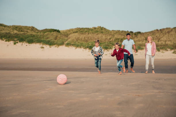 istock Playing Football on the Beach 932362188