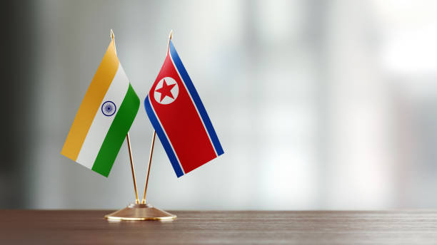 istock Indian And North Korean Flag Pair On A Desk Over Defocused Background 932362898
