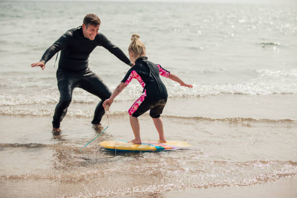 istock Teaching a Little Girl how to Surf 932362944