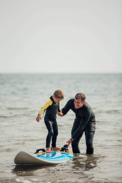 mały chłopiec uczy się surfować - surfing role model learning child zdjęcia i obrazy z banku zdjęć