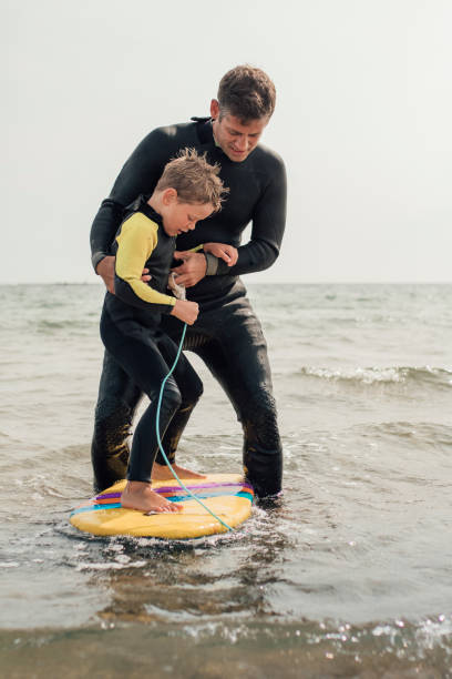nauka surfowania na plaży - surfing role model learning child zdjęcia i obrazy z banku zdjęć