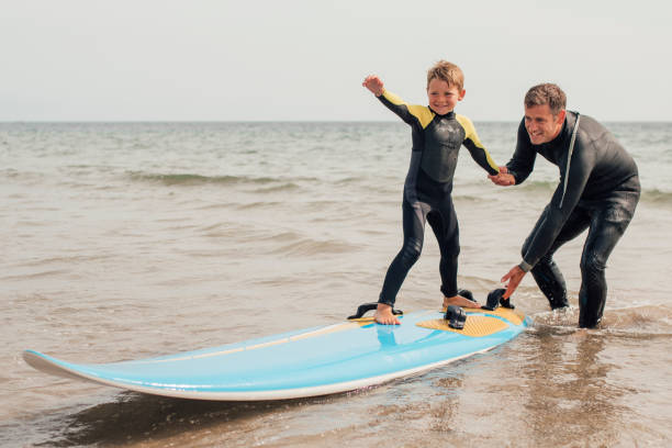 surf con papà in spiaggia - surfing beach family father foto e immagini stock