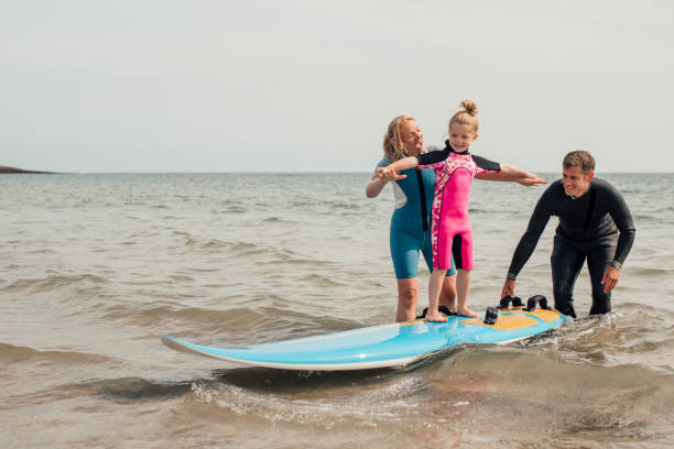 mała dziewczynka uczy się surfować - surfing role model learning child zdjęcia i obrazy z banku zdjęć