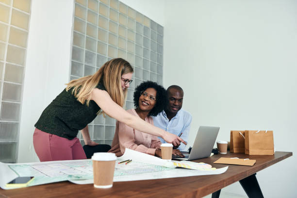 istock Smiling colleagues working together online in a modern office 932372268
