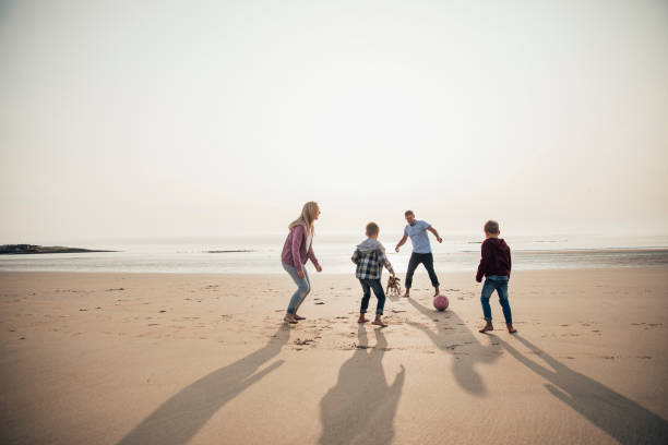 istock Playing Football at the Beach 932372370