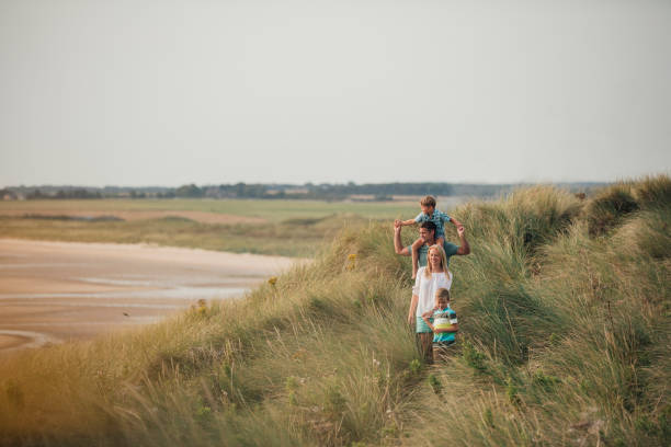 familia caminando por las dunas de arena - the bigger picture refrán en inglés fotografías e imágenes de stock