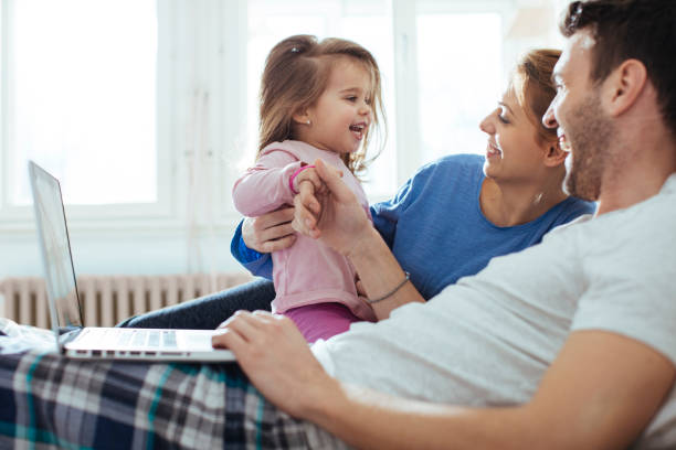 istock Mother and father laughing with daughter 932373302