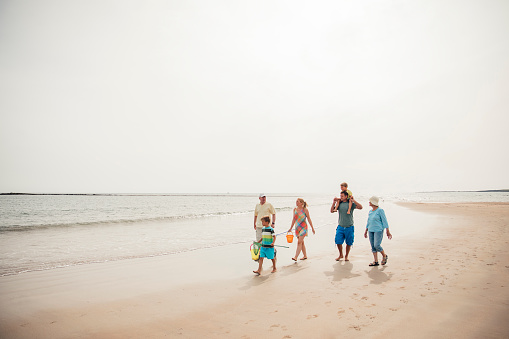 Wide angle view of a family walking along the beach.