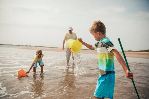 istock Little Boys Playing in the Sea 932375636