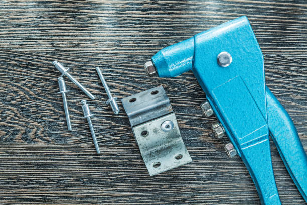 istock Riveting pliers rivets screws on wooden board 932375996
