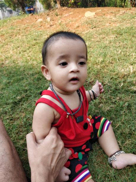 istock Cute little baby sitting on grass 932376170