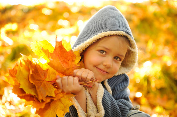istock Playful girl holds autumn leaves. 932376208