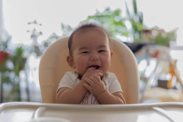 A little boy sitting on highchair and looking at the camera.