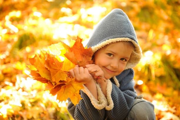 istock Playful girl holds autumn leaves. 932376554