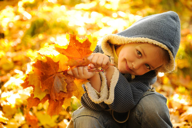 istock Playful girl holds autumn leaves. 932376854