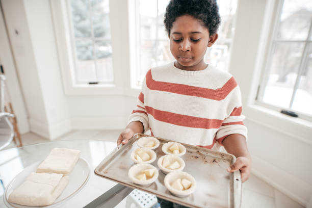 istock 8 years old boy baking cookies in domestic kitchen 932381018