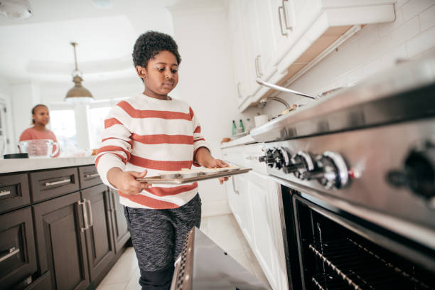 istock 8 years old boy baking cookies in domestic kitchen 932381040