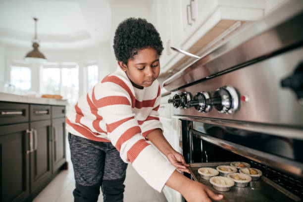 istock 8 years old boy baking cookies in domestic kitchen 932381046