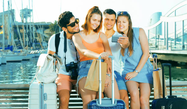 istock Guys and girls taking selfie  on waterfront 932389526