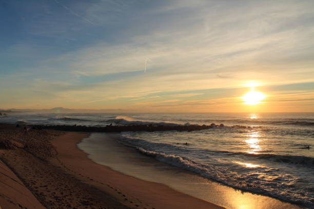 istock golden sunset on beautiful sandy beach with breaking waves in capbreton 932389572