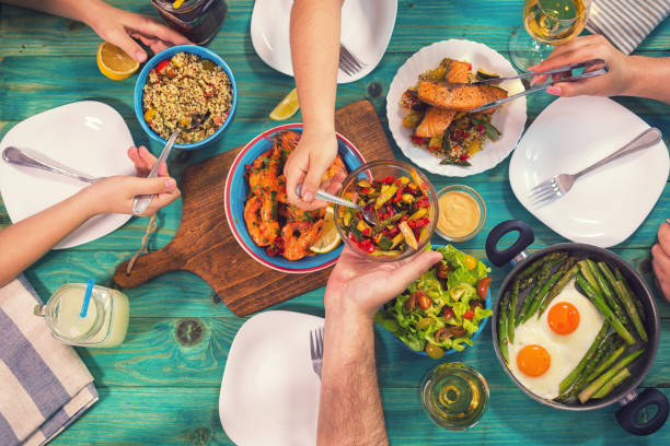 giovane famiglia che pranza a casa - cibo di mediterraneo foto e immagini stock