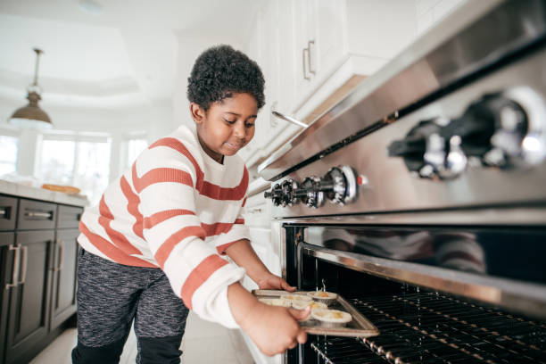 istock 8 years old boy baking cookies in domestic kitchen 932393460